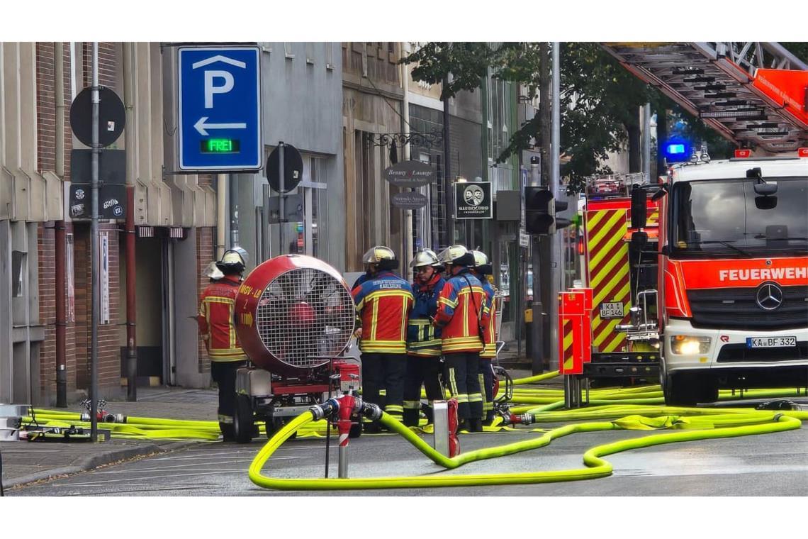 Zahlreiche Feuerwehrleute löschen die brennenden Autos in dem Parkhaus. 