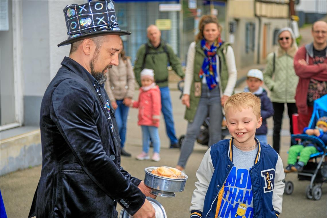 „Das Wetter passt, die Stadt ist voll“ Zauberer Stefan Gottwald und sein junger Assistent, der grinst, weil im Topf plötzlich jede Menge kleiner Überraschungskuchen auftaucht.