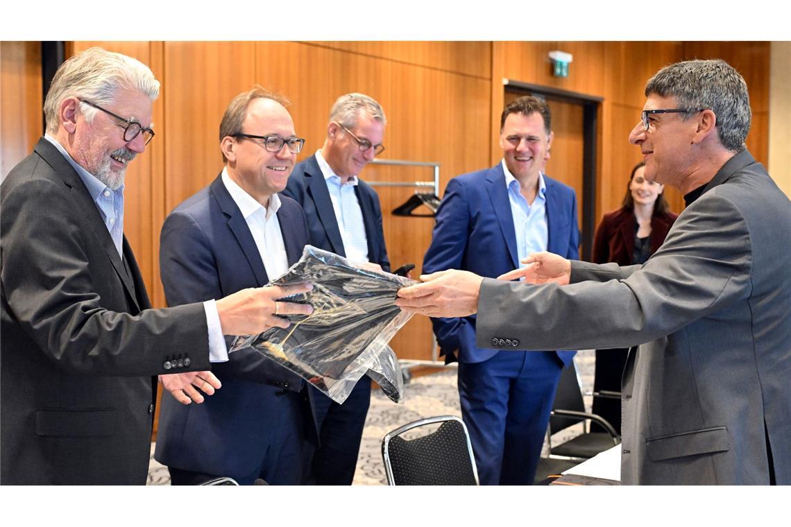Zum Beginn der Tarifverhandlungen in der Stahlindustrie überreicht der Verhandlungsführer der IG Metall, Knut Giesler, zwei T-Shirts an den Verhandlungsführer der Arbeitgeber, Reiner Blaschek (2.v.l), sowie den Geschäftsführer des Arbeitgeberverbandes Stahl, Gerhard Erdmann (l).