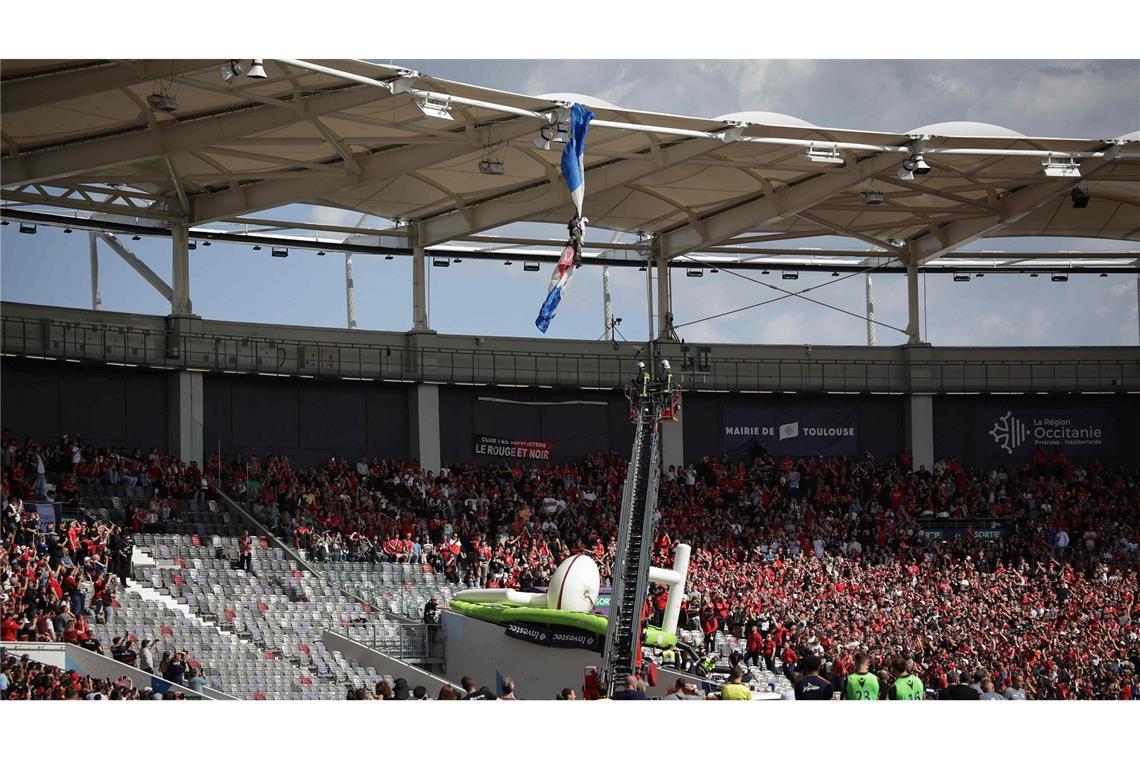 Fallschirmspringer bleibt an Stadiondach in Toulouse hängen Zuschauer beobachten, wie Feuerwehrleute einen Fallschirmspringer der Luftwaffe retten.