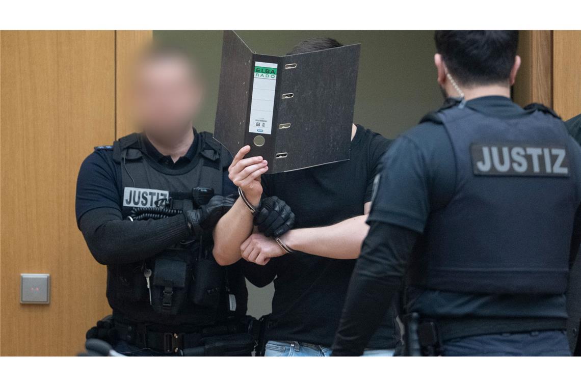 Zwei der Männer verdeckten beim Betreten des Gerichtssaals ihr Gesicht.