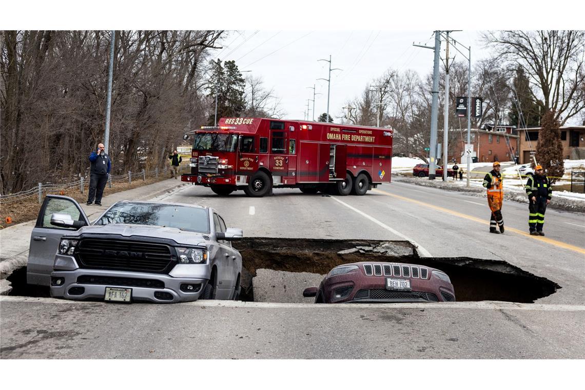Zwei Fahrzeuge liegen auf der Pacific Street östlich der 67th Street in Omaha in einem Sinkloch.