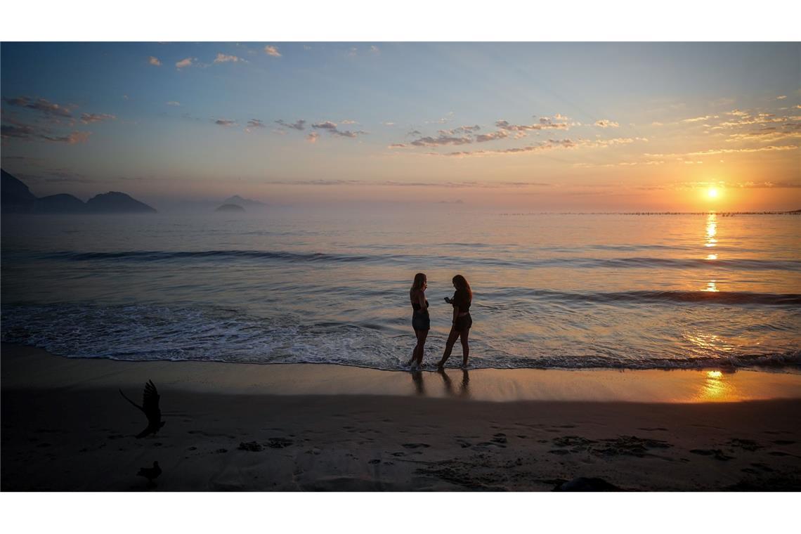 Bilder des Tages Zwei Frauen stehen am Morgen gegen fünf Uhr bei Sonnenaufgang am Strand der Copacabana in Rio. Wegen dem G20-Gipfel, der derzeit in Rio stattfindet, haben die Bürger der Stadt zwei Tage frei bekommen.