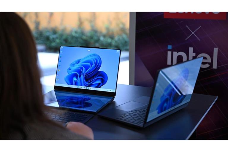 Zwei Lenovo-Laptops, die jeweils zwei Bildschirme haben: Rechts ist der zweite Bildschirm auf der Rückseite des ersten Bildschirms und links sind die beiden Bildschirme nebeneinander montiert - einer liegt vor der Tastatur und dahinter steht der zweite Bildschirm.