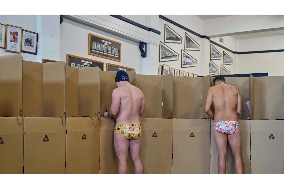 Bilder des Tages Zwei Männer in Badehosen wählen in einem Wahllokal am Bondi Beach in Sydney. In Australien sind mehr als 18 Millionen Menschen aufgerufen, ein neues Parlament zu wählen.