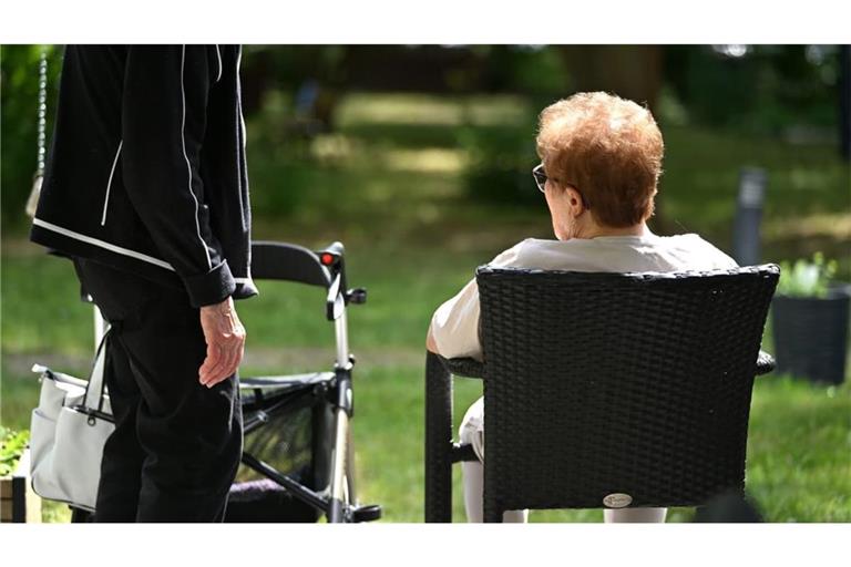 Zwei Senioren sprechen in dem Garten eines Pflegeheims miteinander. Die Bundesregierung plant höhere Belastungen für kinderlose Versicherte.