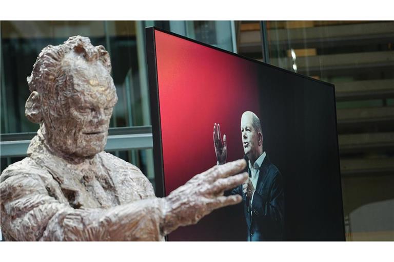Zwei SPD-Kanzler, als Statue und auf dem Bildschirm: Willy Brandt und Olaf Scholz